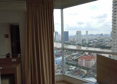 Spacious bedroom with large window overlooking city and river