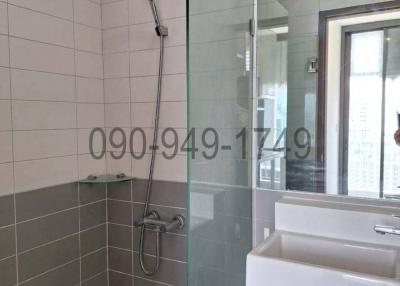 Modern bathroom with glass shower partition and wall-mounted showerhead