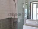 Modern bathroom with glass shower partition and wall-mounted showerhead