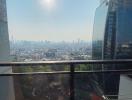 City view from high-rise apartment balcony with clear skies