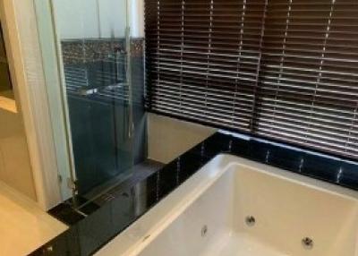 Modern bathroom with a large tub and window blinds