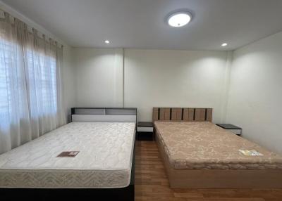 Spacious bedroom with two beds and ample lighting