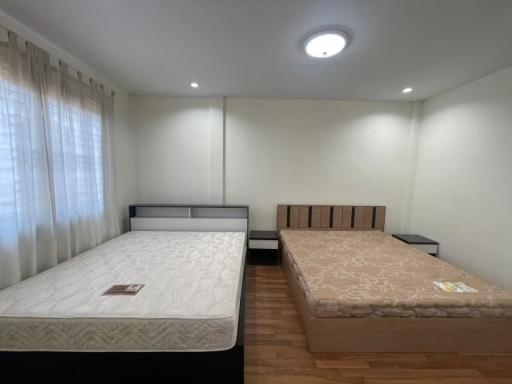 Spacious bedroom with two beds and ample lighting