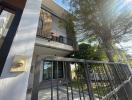 Exterior view of a two-story residential building with a gated fence