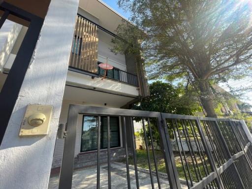 Exterior view of a two-story residential building with a gated fence