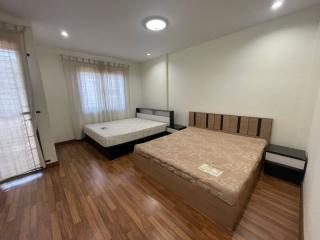 Spacious bedroom with two beds and wooden flooring