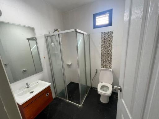 Modern bathroom with glass shower enclosure and patterned tile accent