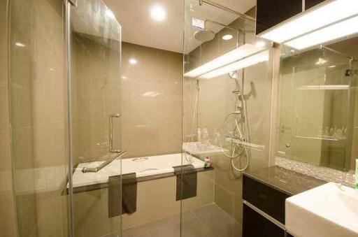 Modern bathroom with glass shower and well-lit mirror