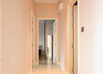 Narrow hallway in a residential home with light walls and tiled flooring