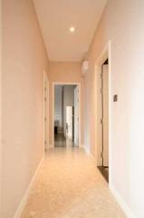 Narrow hallway in a residential home with light walls and tiled flooring