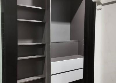Built-in dark-colored closet with shelves and drawers