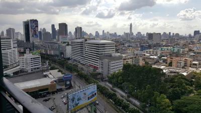 Expansive city view from a high vantage point, showcasing urban skyline with clouds