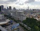 Expansive city view from a high vantage point, showcasing urban skyline with clouds