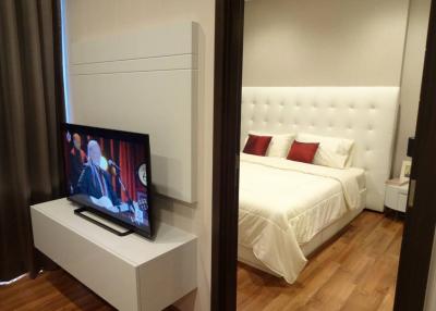 Modern bedroom with a white bed and television