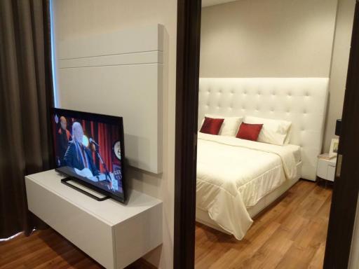 Modern bedroom with a white bed and television