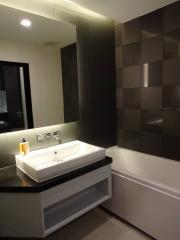 Modern bathroom with dark tiles and white sink