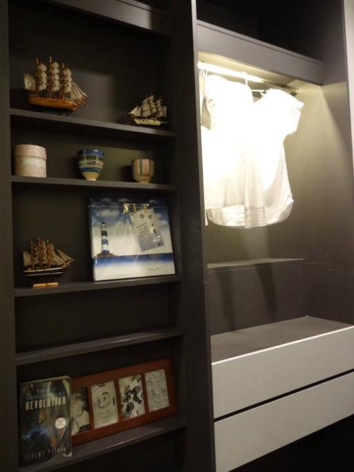 Well-organized closet with shelves and illuminated hanging area