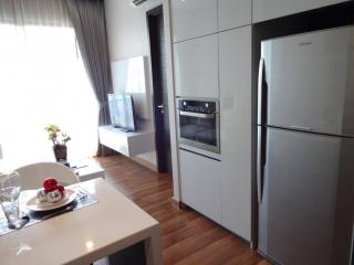 Modern kitchen with stainless steel appliances and adjacent living area