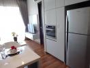 Modern kitchen with stainless steel appliances and adjacent living area