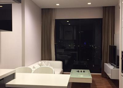 Modern apartment interior with open plan living space, featuring a dining area, comfortable lounge, and city view