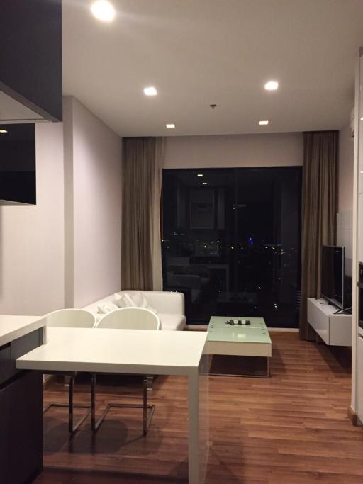 Modern apartment interior with open plan living space, featuring a dining area, comfortable lounge, and city view