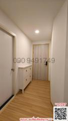 Brightly lit hallway with wooden flooring and white walls