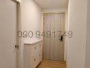 Brightly lit hallway with wooden flooring and white walls