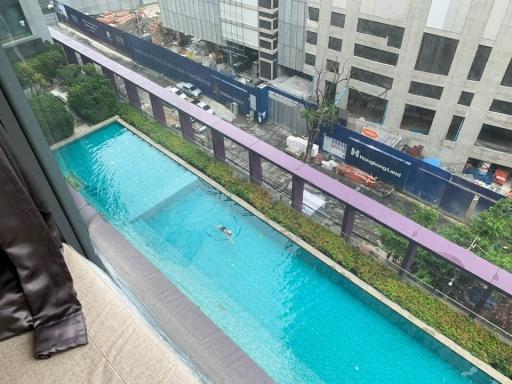 View from apartment window showcasing swimming pool and city surroundings