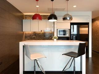 Modern kitchen with bar-style seating, pendant lighting, and stainless steel appliances