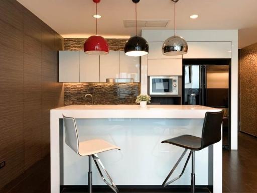 Modern kitchen with bar-style seating, pendant lighting, and stainless steel appliances