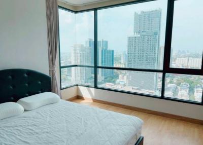 Modern bedroom with large windows offering a panoramic city view