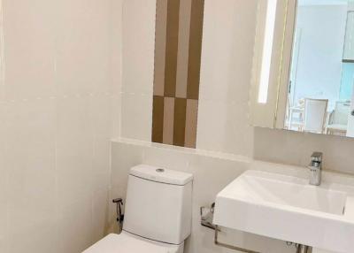 Modern bathroom with white fixtures and decorative brown accent tiles