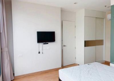 Modern bedroom with mounted television and wooden floor