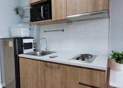 Modern compact kitchen with wooden cabinets and stainless steel appliances