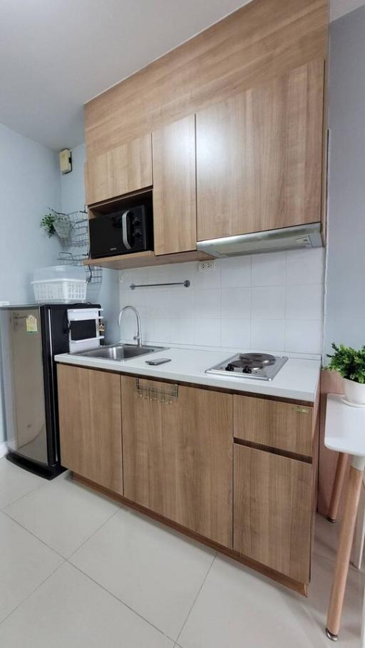 Modern compact kitchen with wooden cabinets and stainless steel appliances