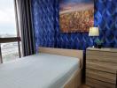 Cozy bedroom with blue geometric pattern wallpaper and cityscape artwork