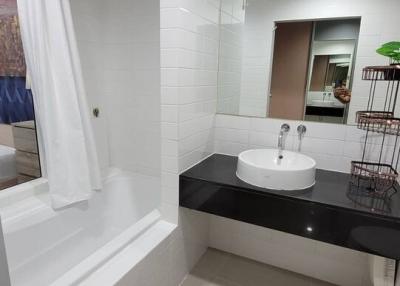Modern bathroom with white tiles and bathtub