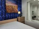 Modern bedroom interior with art on the wall and glimpse of en-suite bathroom