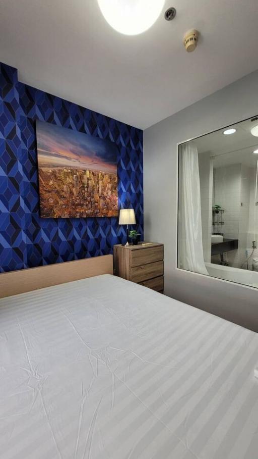 Modern bedroom interior with art on the wall and glimpse of en-suite bathroom