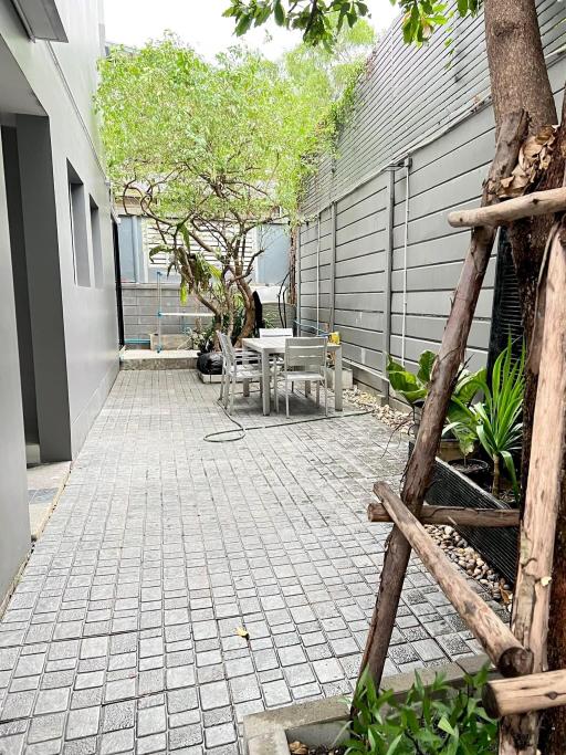 Paved outdoor seating area with greenery and modern design