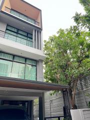 Modern multi-story residential building with large windows and balcony