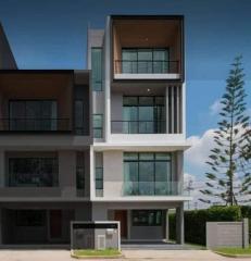 Modern three-story residential building with balconies and large windows