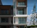 Modern three-story residential building with balconies and large windows