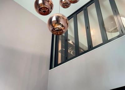 Modern interior with copper pendant lights and a second-story window