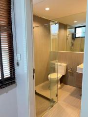 Modern bathroom with glass shower enclosure and wooden accents