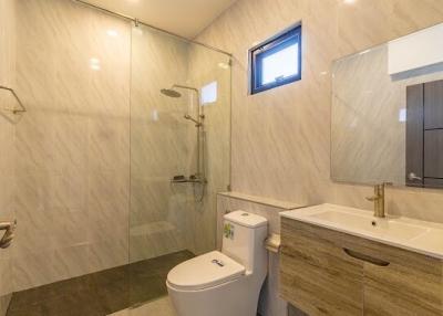 Modern bathroom interior with glass shower, wall-mounted toilet, and sink