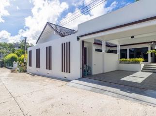 Front view of a modern single-level house with a large entrance and driveway