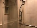 Modern bathroom with glass shower enclosure and wall-mounted shower system