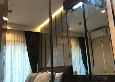 Modern bedroom with large mirror and ambient lighting