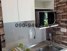 Modern kitchen with brick wall accent and white cabinetry